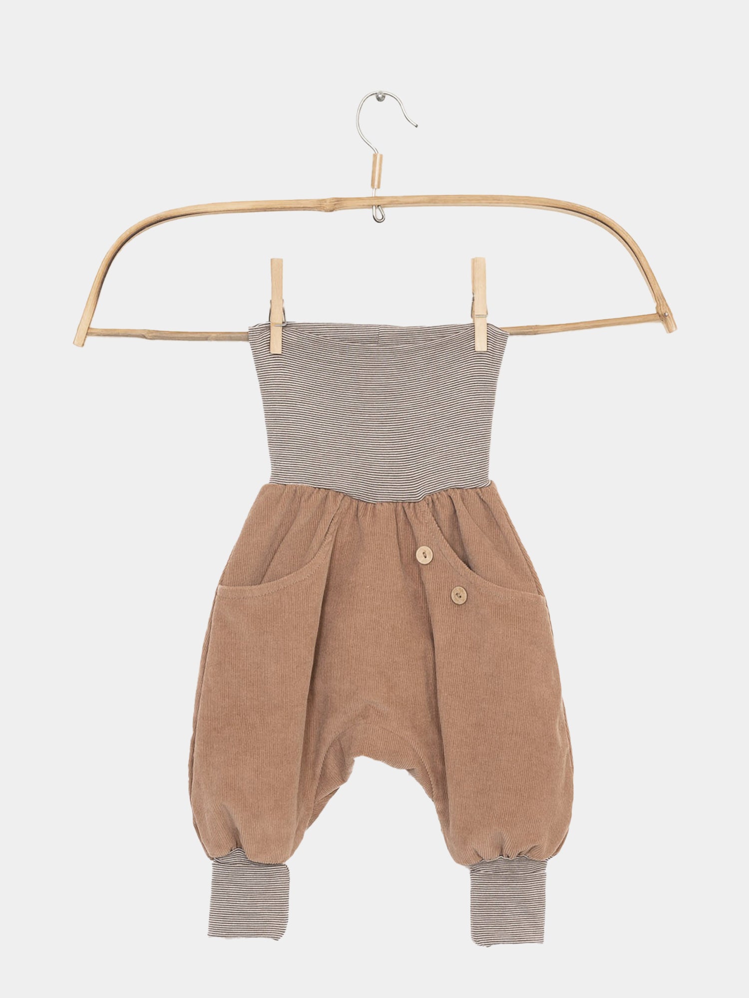 Knickerbocker Feincord Ringel - Weizen: Einteiler mit gestreiftem Strick-Bund, braunem Cord-Hosenbein, seitlichen Taschen, Holzknebelknöpfen und gestreiften Bündchen, auf einem Holzkleiderbügel vor neutralem Hintergrund präsentiert.