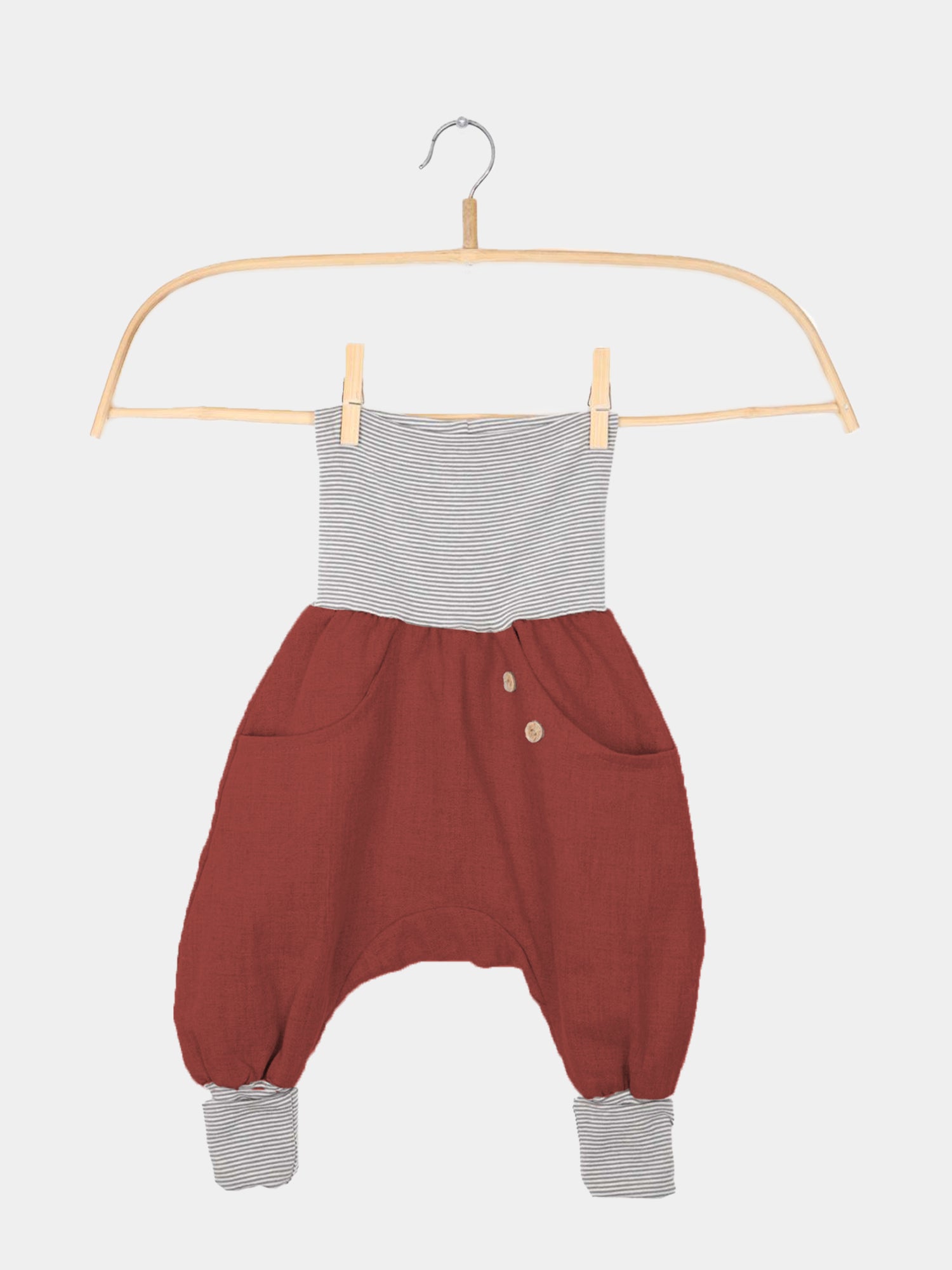 Knickerbocker Leinen - Terracotta: Kinder-Einteiler mit schwarz-weiß gestreiftem Tube-Top, haremartigen Hosen mit tiefem Schritt und rust-rotem Stoff, zwei Taschen, dekorativen Holzknöpfen und gestreiften Bündchen.