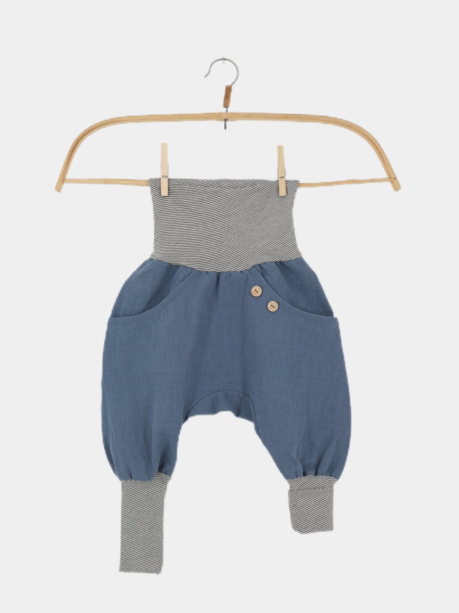 Knickerbocker Leinen - Blaubeere: Kinder-Haremshose mit grauen Streifenbündchen, lockerem blauen Leinenkörper, Fronttaschen und dekorativen Holzknöpfen auf einem Holzkleiderbügel. Ideal für aktive Kinder an warmen Tagen.