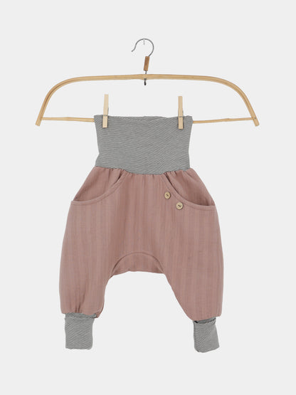 Knickerbocker Musselin aus 100% Bio-Baumwolle - Puder: Luftige Haremshose für Kinder mit rosafarbenem Musselin, schwarz-weiß gestreiftem Bund und Knöcheln, zwei Holzknöpfen und Taschen, ideal für Sommerabenteuer.