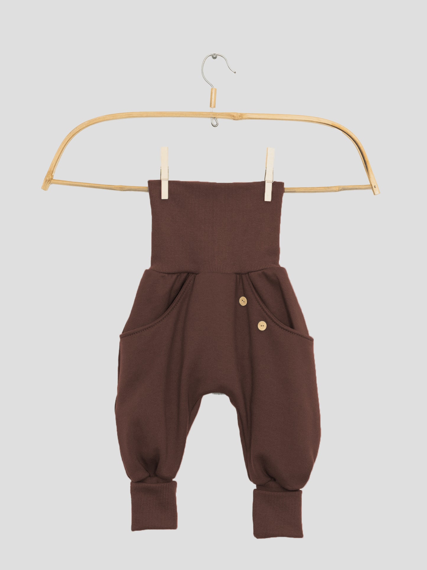 Nahaufnahme der Knickerbocker Bio-Sweat - Schoko mit durchgehender Kängurutasche, klassischen PETIT COCHON Schnitt und Krempelbündchen, die Bewegungsfreiheit bieten. Kombiniert perfekt mit Schlüttli Bio-Sweat.