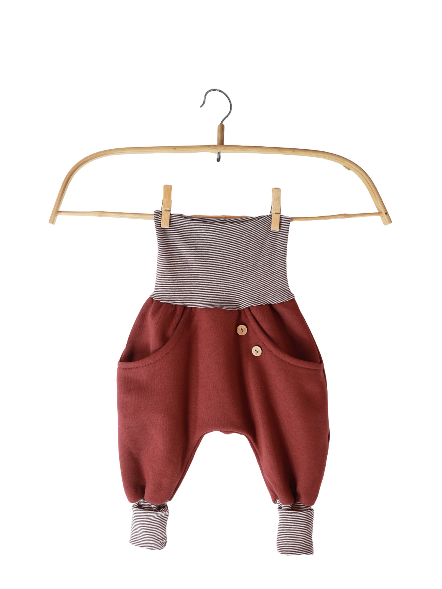 Knickerbocker Bio-Sweat mit Ringelbündchen - Burgund auf einem Kleiderbügel, mit lockerer Passform und großer Kängurutasche, präsentiert auf einem Holzschwinger. Ideal für Alltag und Bewegung.