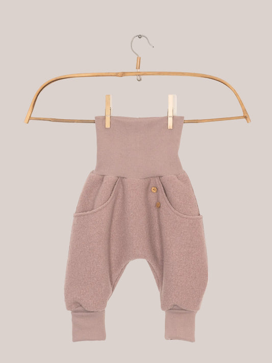 Knickerbocker boiled wool - Powder: Pink grow-with-me children’s trousers with kangaroo pockets, boiled wool fabric on a clothesline, ideal for cold weather. Unisex design, handmade in Berlin, durable and weather-resistant.