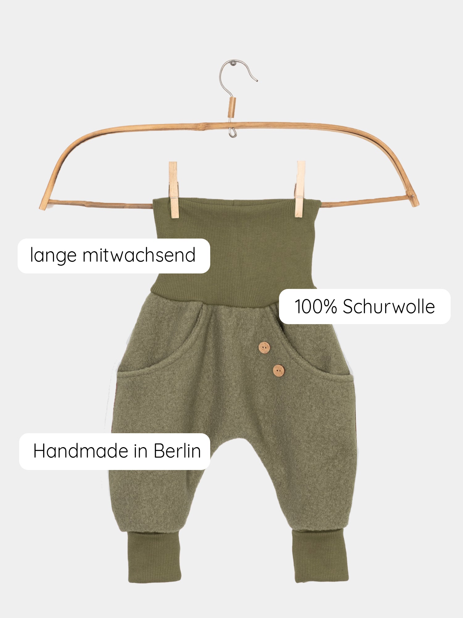 Knickerbocker Wollwalk - Pistazie auf einem Kleiderbügel, mit sichtbaren Kängurutaschen und Bio-Baumwollbündchen. Perfekt für kaltes Wetter, bietet Komfort und Schutz vor Nässe, unisex und handgefertigt in Berlin.