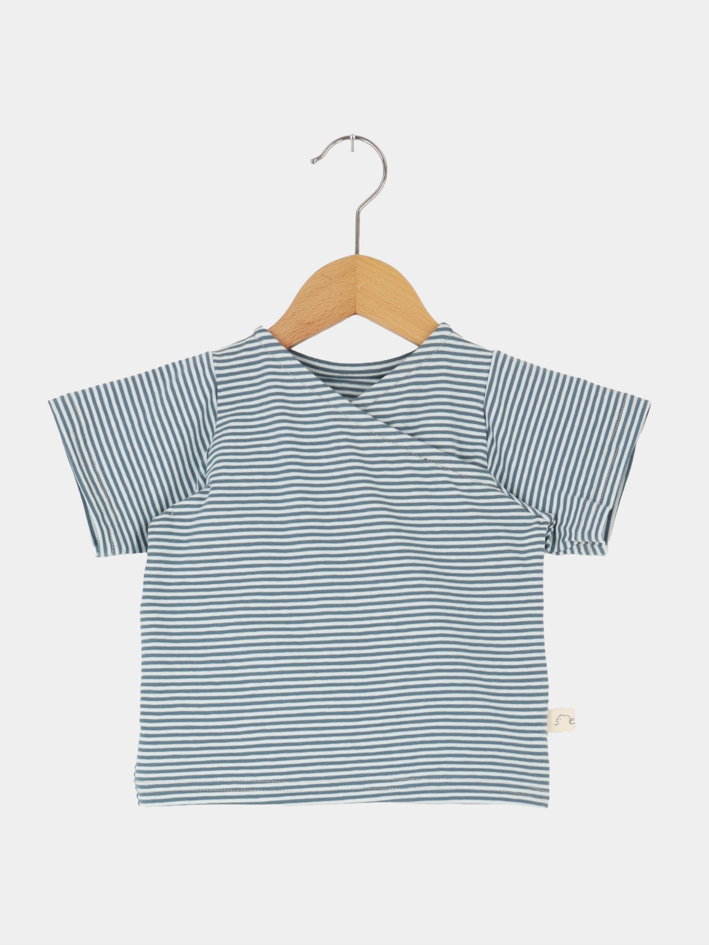 Kurzes Wickelshirt Baumwolle - Ringel Taube auf Holzbügel, mit kurzen Ärmeln und feinen blauen und weißen Streifen, zeigt einen kimonoartigen Wickelausschnitt, ideal für sommerliche Outfits.