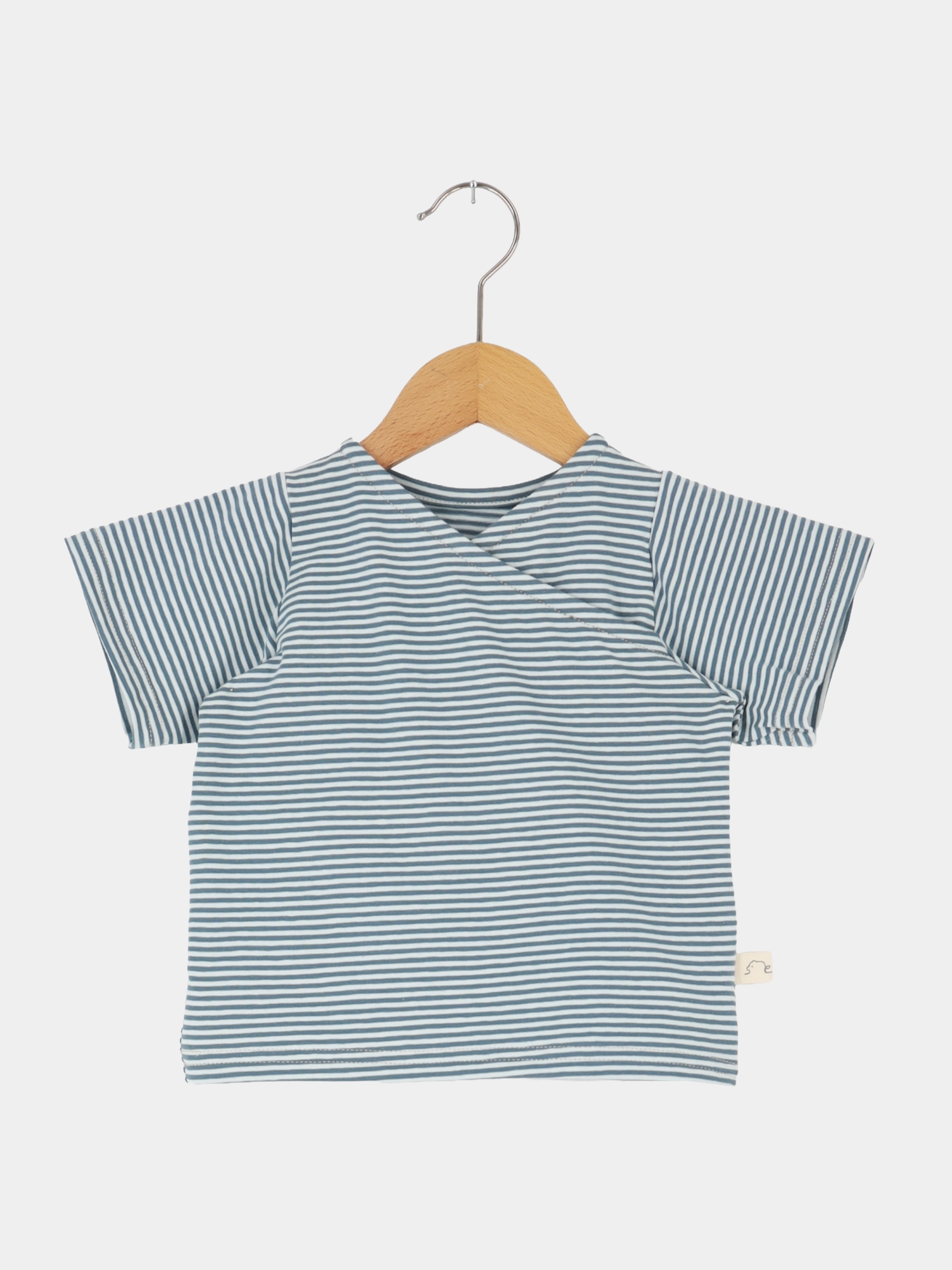 Kurzes Wickelshirt Baumwolle - Ringel Taube auf Holzbügel, mit kurzen Ärmeln und feinen blauen und weißen Streifen, zeigt einen kimonoartigen Wickelausschnitt, ideal für sommerliche Outfits.