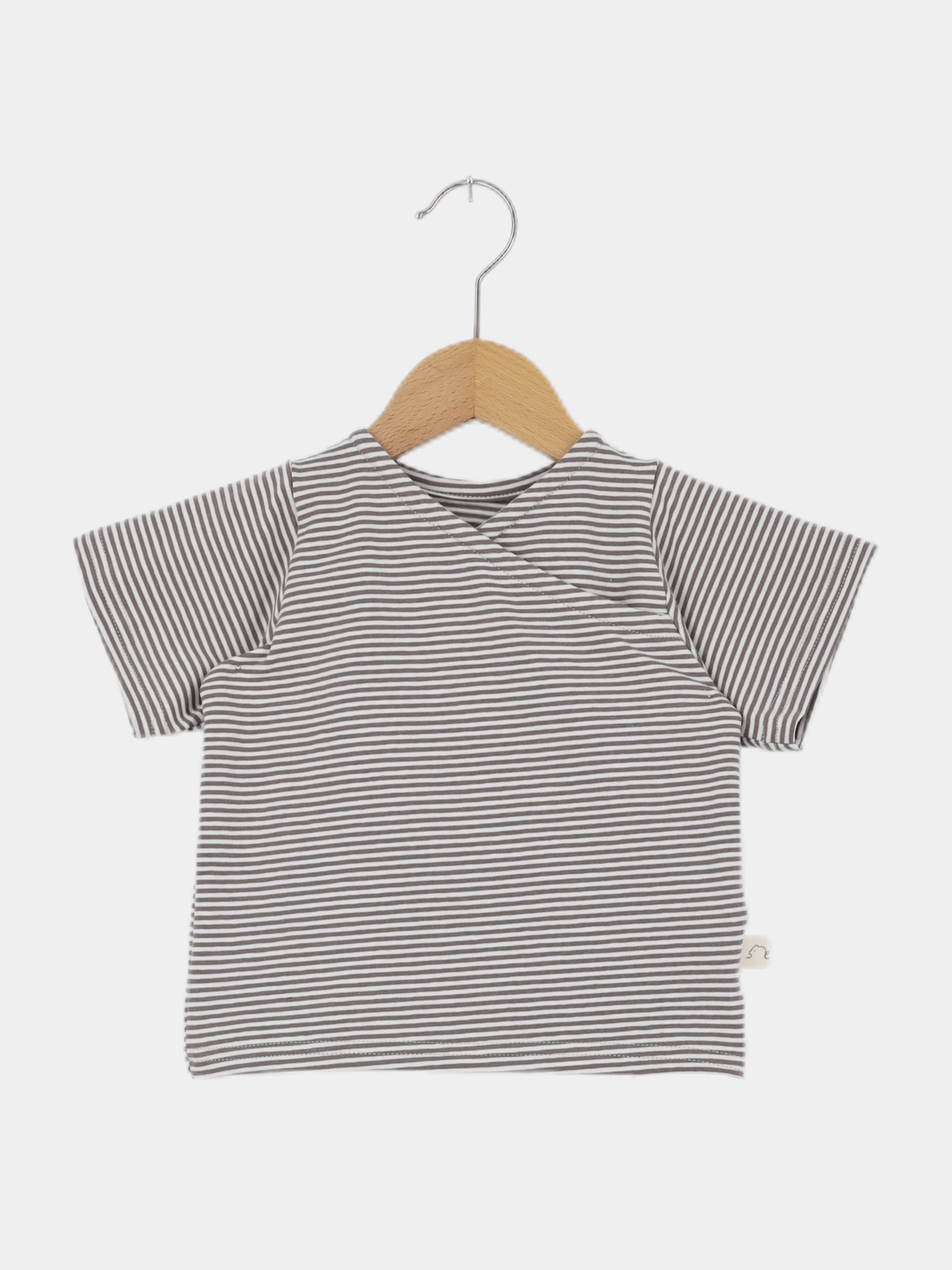 Kurzes Wickelshirt Baumwolle - Ringel Praline: Kurzärmeliges Shirt mit schmalen grauen und weißen Streifen, präsentiert auf einem Holzkleiderbügel. Ideal für Kinder, handgefertigt in Berlin aus atmungsaktiver Baumwolle.