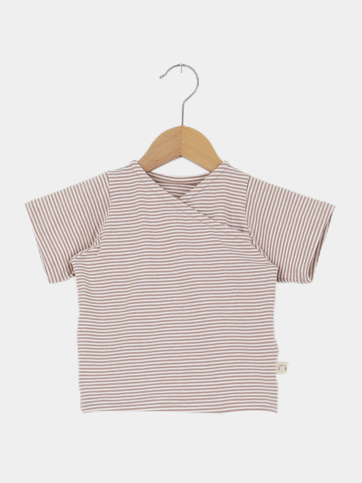 Kurzes Wickelshirt Baumwolle - Ringel Weizen, ein kurzärmeliges, gestreiftes Oberteil im Wickelstil, hängt auf einem Holzkleiderbügel. Es ist weich, bequem und aus Ökotex-zertifizierter Baumwolle handgemacht in Berlin.