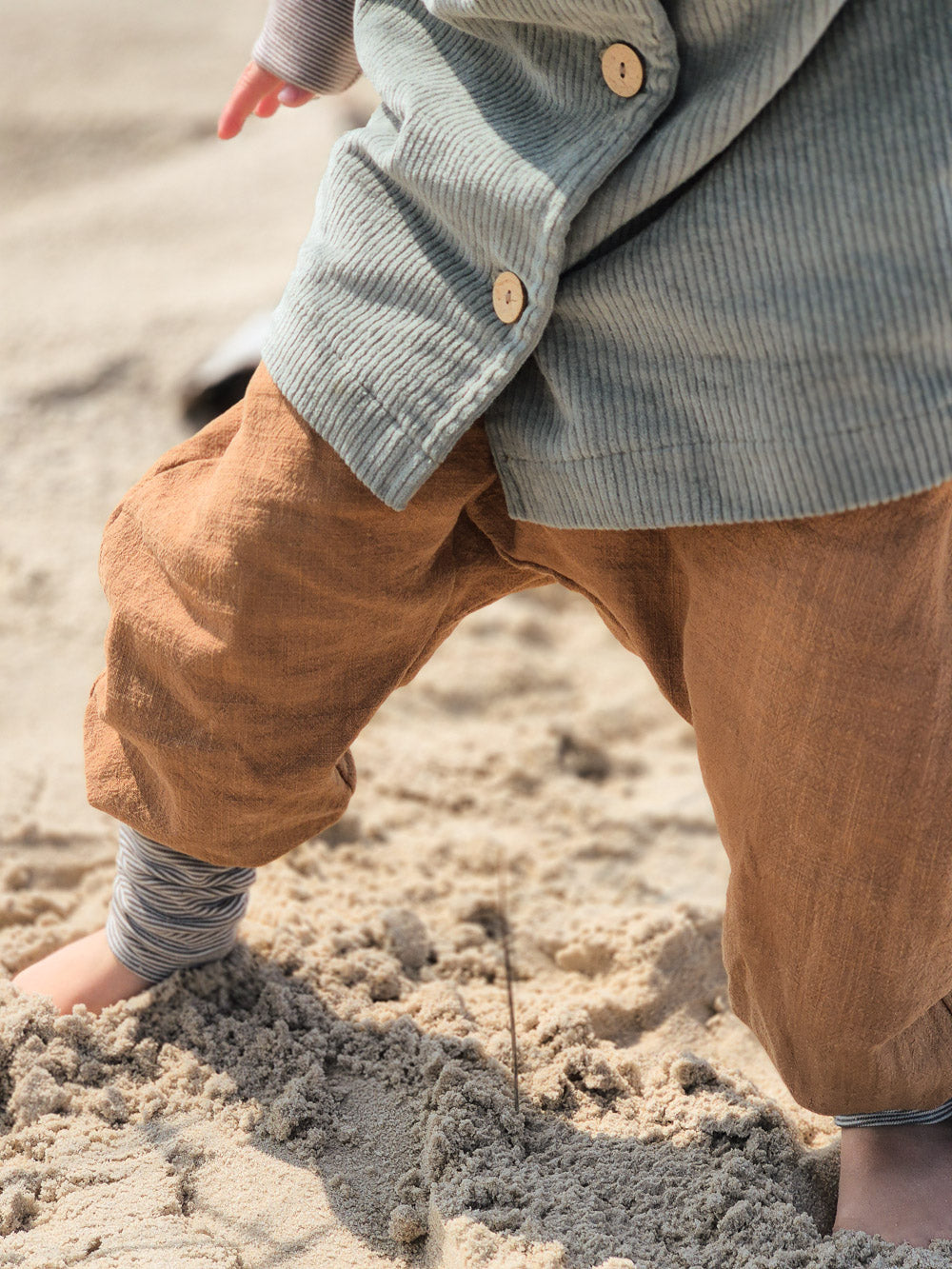 petit cochon Knickerbocker aus braunem Leinen für Kinder, getragen am Strand mit mitwachsenden Bündchen
