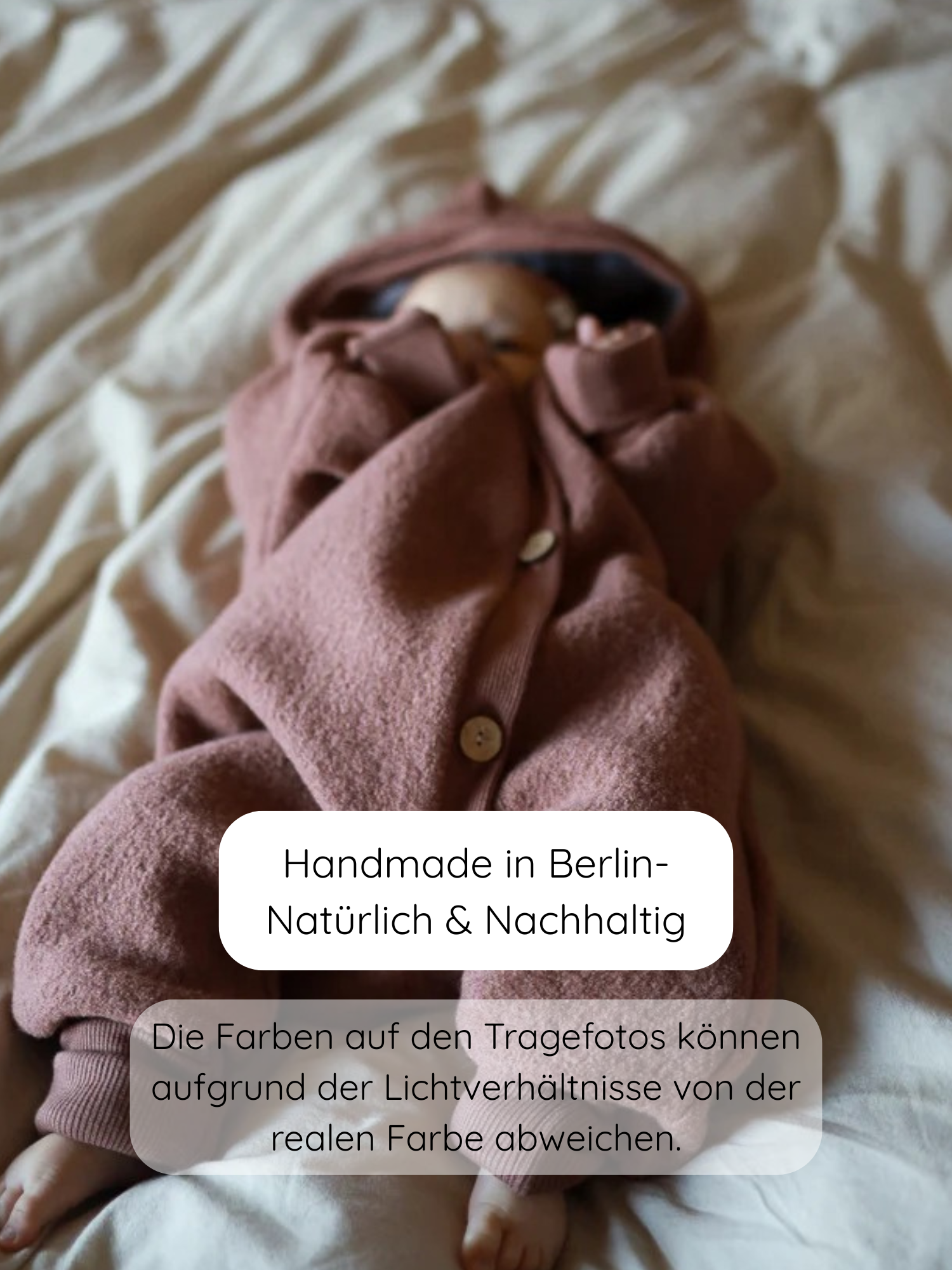 Baby in Kuschelanzug Wollwalk - Zimt aus 100% Schurwolle, weich gefüttert, mit Kapuze und Holzknöpfen, liegt auf neutralem Untergrund. Handgefertigt in Berlin, nachhaltig und temperaturausgleichend.
