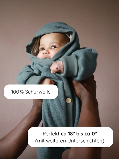 Baby im Kuschelanzug Wollwalk - Taube aus 100% Schurwolle, gehalten von Erwachsenen. Ideal für 18°C bis 0°C. Perfekt für Tragetaschen, mit langen Bündchen gegen Kälte und niedlicher Wichtelkapuze.