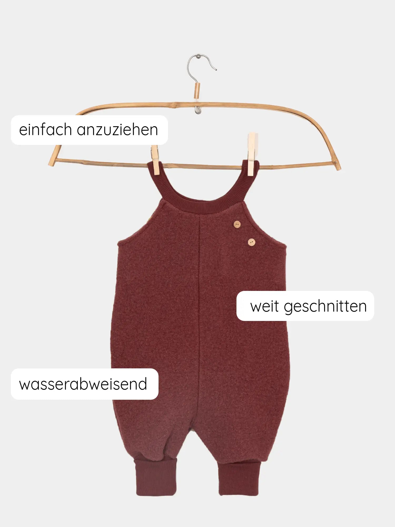 Schlupflatzhose Wollwalk aus 100% Schurwolle - Ziegel auf Holzkleiderbügel, maroonfarben, mit deutschen Merkmalen: einfach anzuziehen, weit geschnitten, wasserabweisend. Ideal für Herbst- und Winterabenteuer.