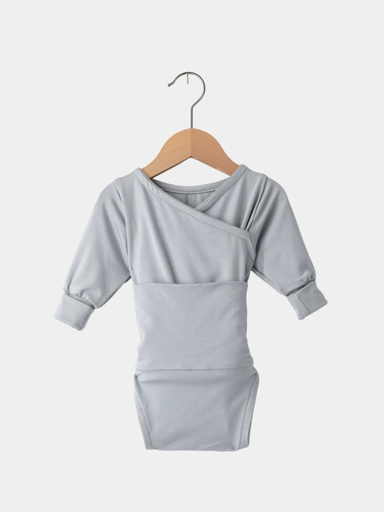 Loopbody Bambusviskose - Eisblau: Helles, langärmeliges Baby-Body mit kimonoartigem Ausschnitt, auf einem Holzkleiderbügel präsentiert.