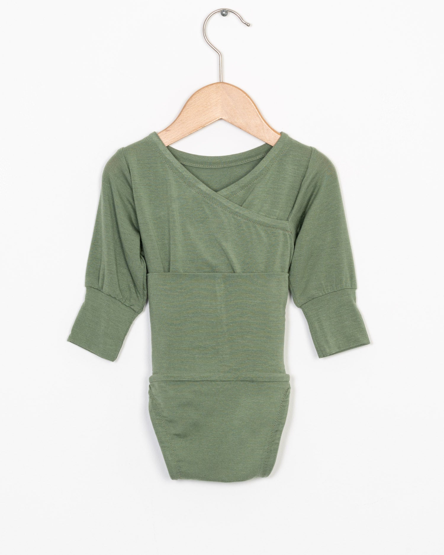 Loopbody Kaschmir Eukalyptus Gr. 0M in sagegrün, drei Viertel Ärmel, kimonoartiger Ausschnitt, präsentiert auf einem einfachen Holzkleiderbügel vor weißem Hintergrund. Zustand: neu.