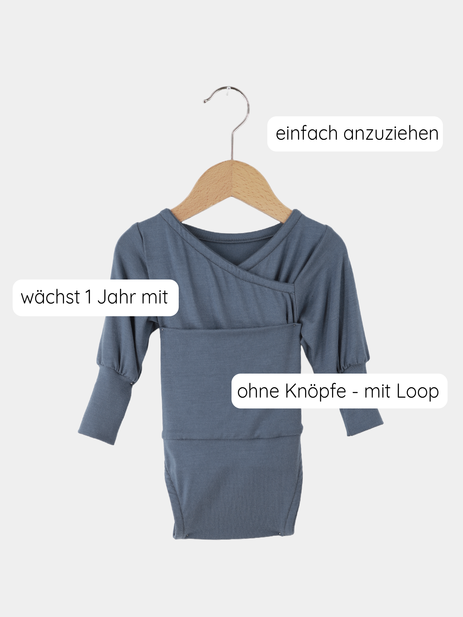 Nahaufnahme des Loopbody Tencel - mitwachsender Babybody - Blaubeere: Weicher Stoff mit langen Ärmeln, auf einem Kleiderbügel präsentiert, betont seine Funktionalität und den Komfort für Babys.