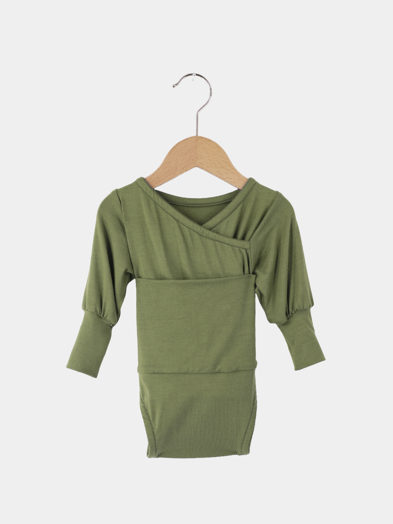 Loopbody Tencel - mitwachsender Babybody - Apfel: Ein grüner Babybody aus Tencel auf einer Schaukel, zeigt weiches, atmungsaktives Material, ohne sichtbare Knöpfe, ideal für bequeme, körpernahe Kleidung.