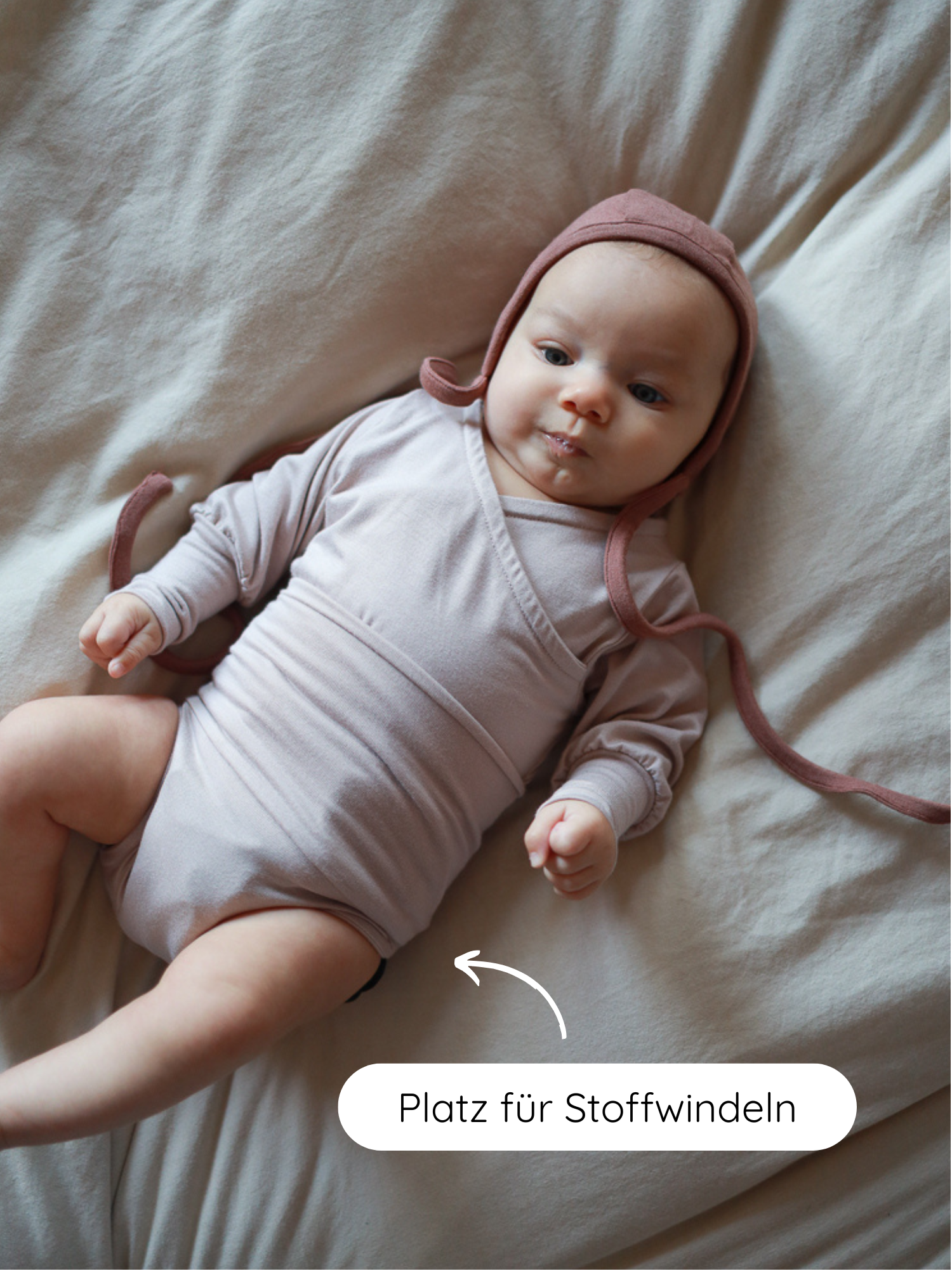 Ein Baby trägt einen Loopbody Bambusviskose - Cremepuder, mitwachsend und für Stoffwindeln geeignet. Ein Pfeil zeigt auf den Windelbereich, dazu der Hinweis Platz für Stoffwindeln.