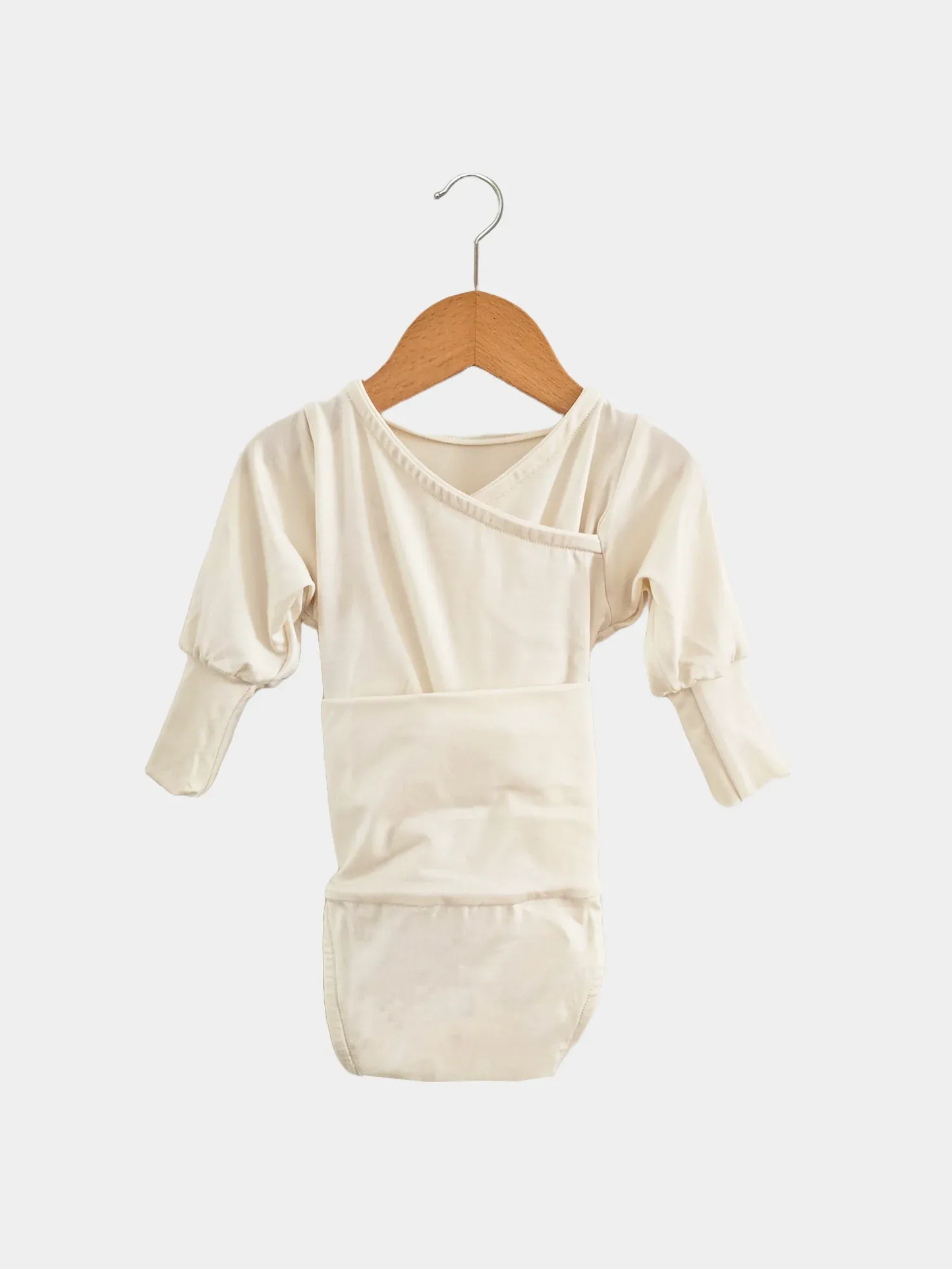 Loopbody Bambusviskose - Natur: Kimono-Stil, langen Ärmeln, eingebautem Bauchband, Wickelverschluss ohne Knöpfe. Hängt an einem Holzkleiderbügel, designed für Komfort und Mitwachsen des Babys.