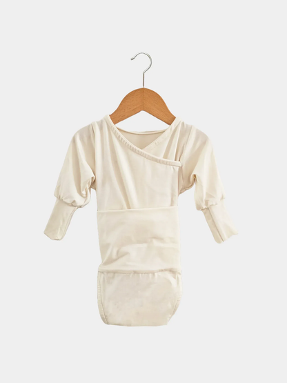 Loopbody Bambusviskose - Natur: Kimono-Stil, langen Ärmeln, eingebautem Bauchband, Wickelverschluss ohne Knöpfe. Hängt an einem Holzkleiderbügel, designed für Komfort und Mitwachsen des Babys.