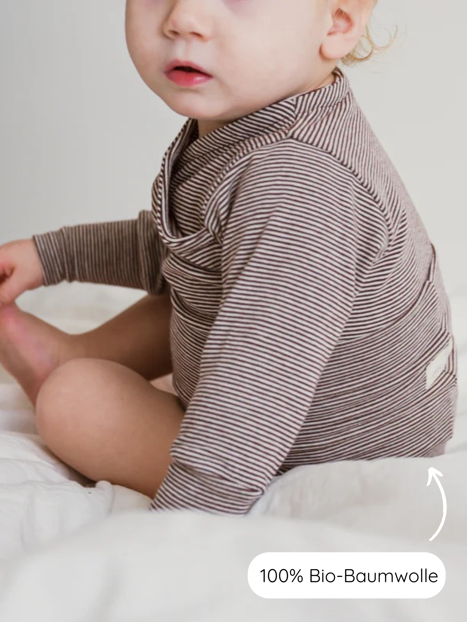 Kleines Kind trägt einen Loopbody Bio-Baumwolle-Ringel Schoko, einen braun-weiß gestreiften, langärmligen Strampler aus 100% Bio-Baumwolle, der bis zu einem Jahr mitwächst.
