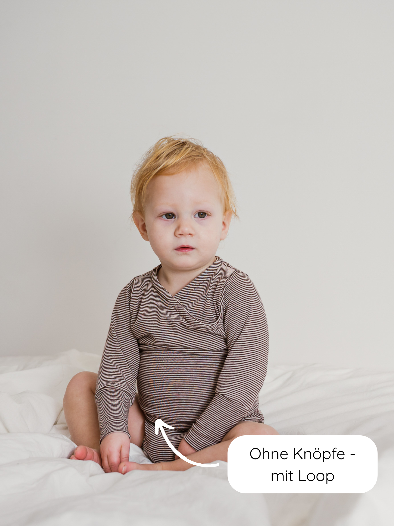 Kleinkind im Loopbody Bio-Baumwolle-Ringel Schoko, langärmelig, ohne Knöpfe mit Loop. Nachhaltig und mitwachsend. Schlichte Umgebung, Fokus auf dem innovativen, unisex Design von PETIT COCHON.