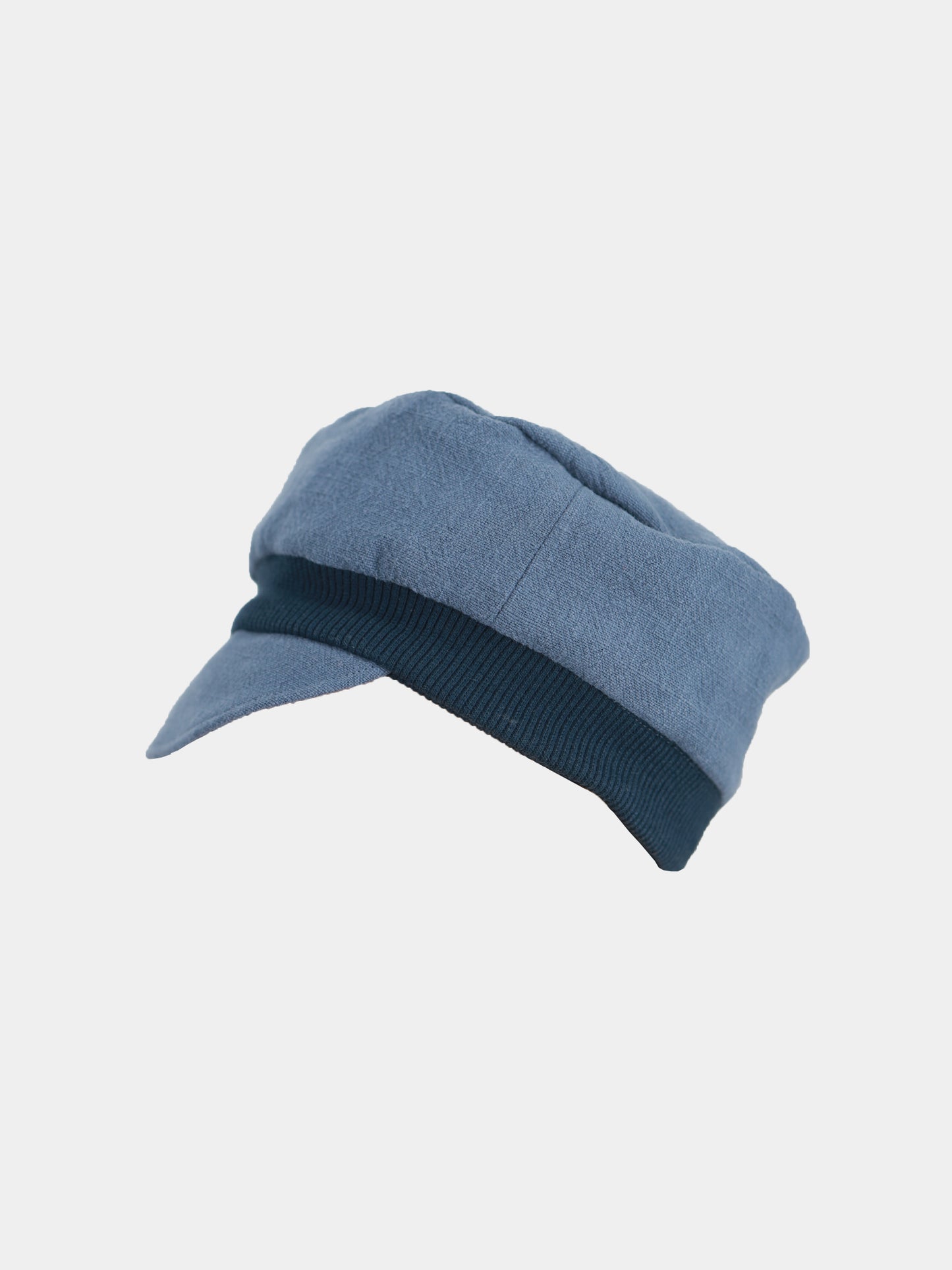 Die Michelmütze Leinen - Blaubeere ist eine stilvolle Schiebermütze aus Baumwolle mit kleinem Schirm, präsentiert vor einem schlichten Hintergrund, ideal für einen klassischen, modischen Look.