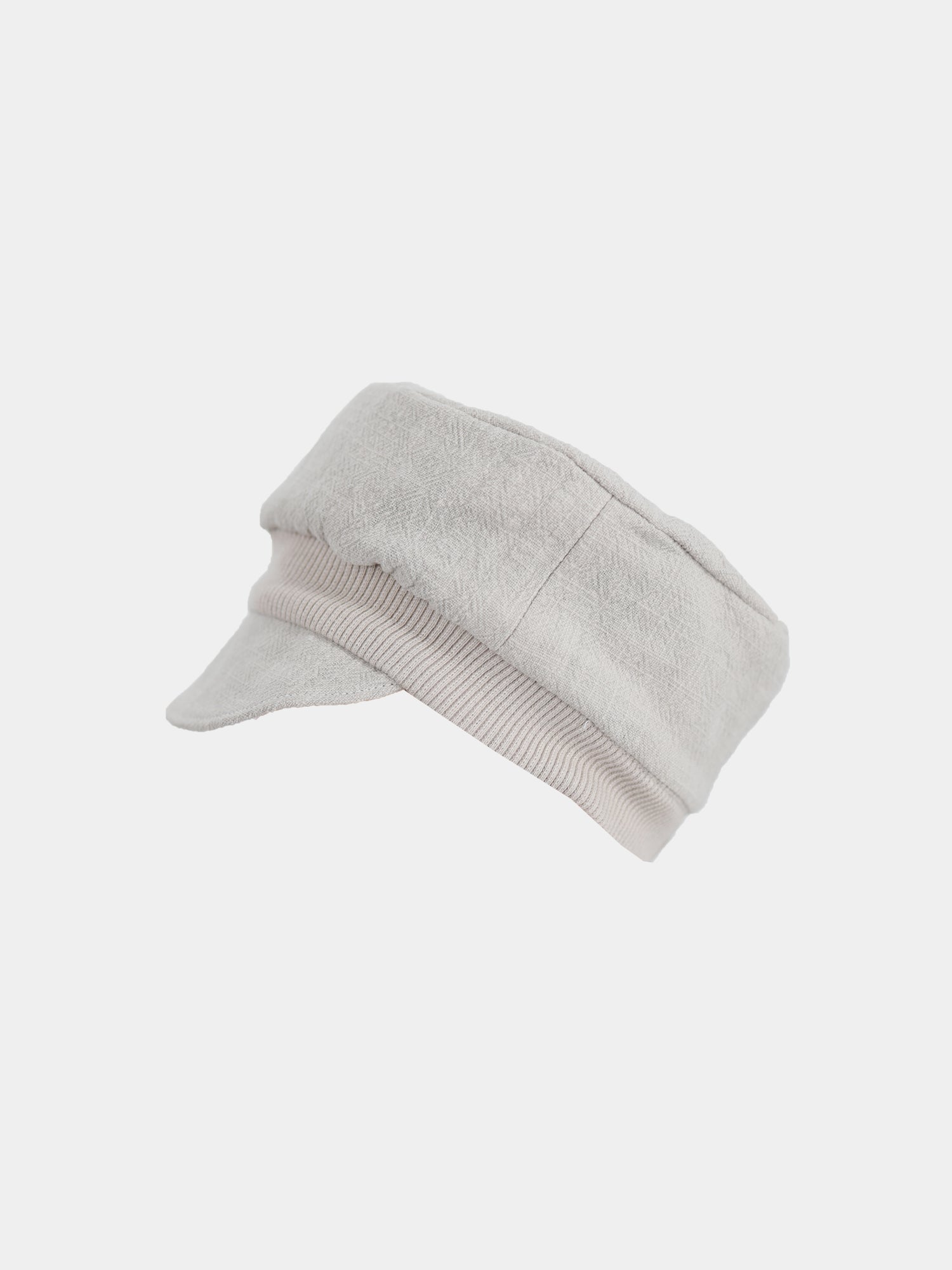 Michelmütze Leinen - Sand: Leichte, beige Stoffkappe im Fischer oder Griechischer Briefträger Stil mit leicht gebogenem Schirm und weicher, flacher Krone, vor weißem Hintergrund fotografiert.