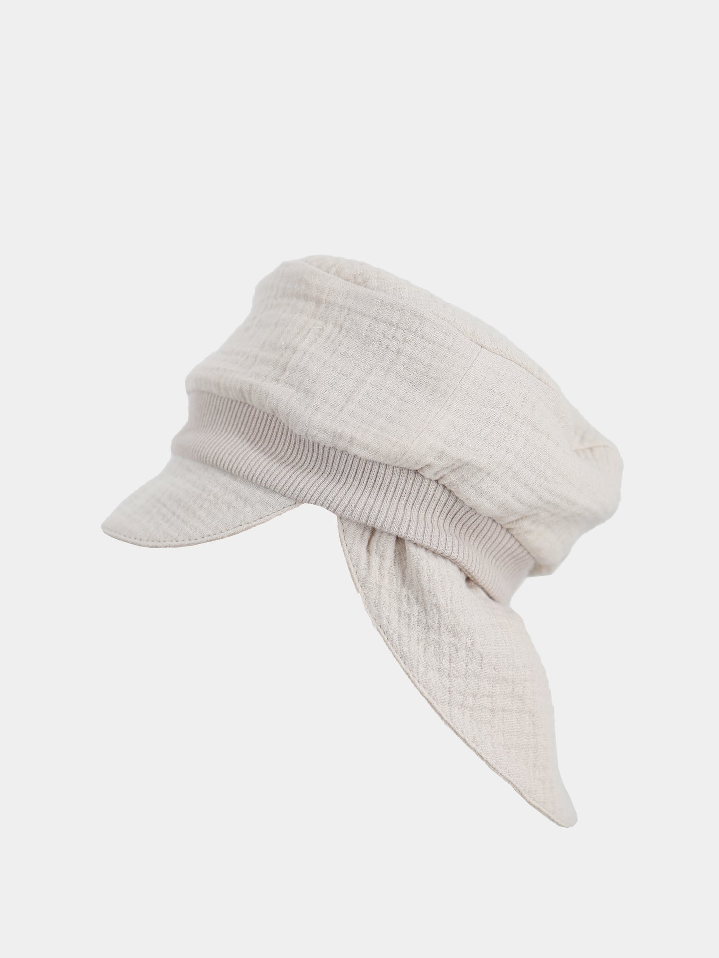 Die Michelmütze Bio-Musselin mit Nackenschutz - Sand ist eine leichte, beige Mütze im Baker-Boy-Stil mit kurzem Schirm und lockeren, schalartigen Paneelen, ideal für sommerlichen Sonnenschutz.