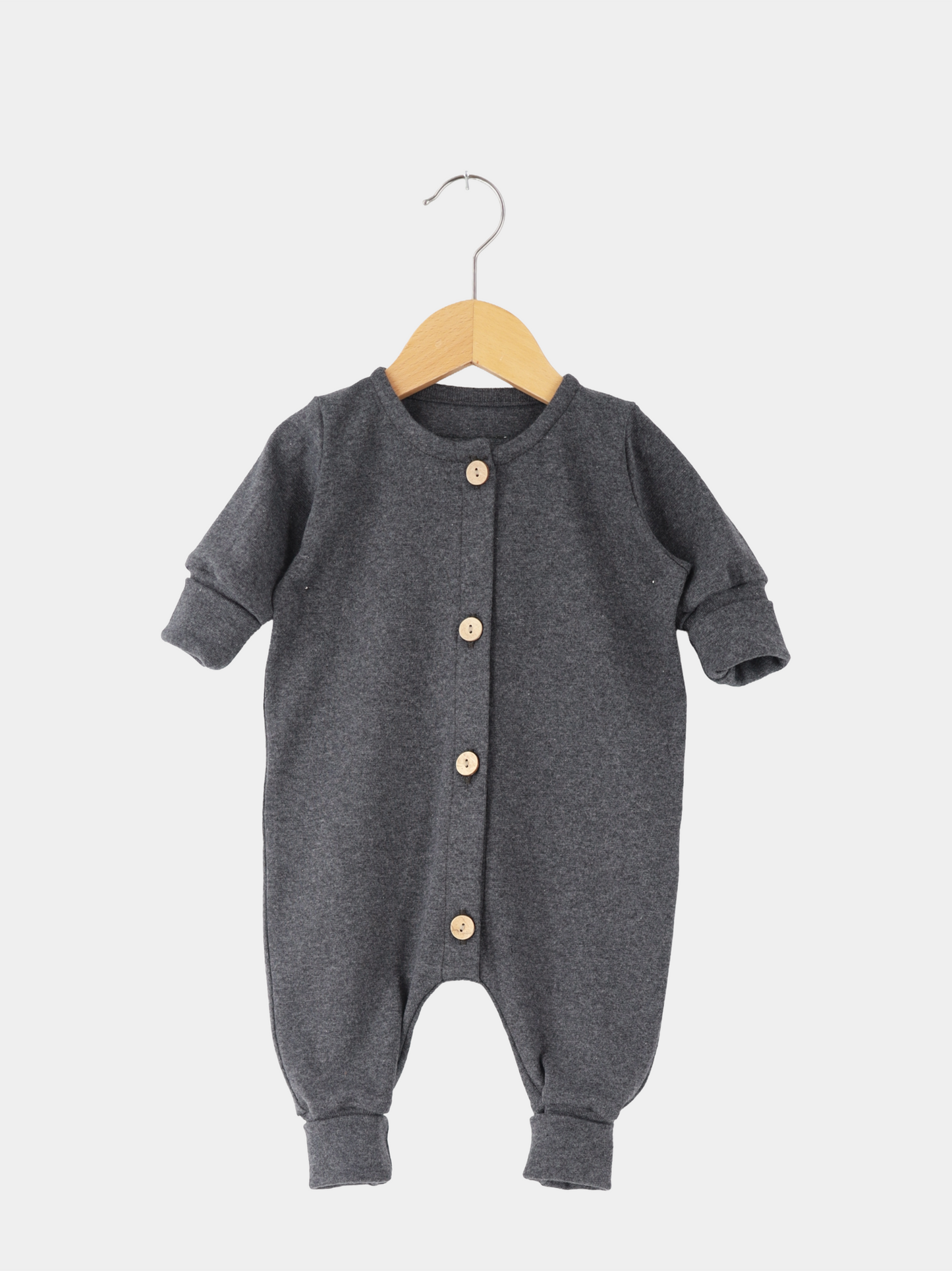 Mini Overall Feinstrick - Ruß Meliert: Dunkelgrauer langärmeliger Babystrampler mit Rundhalsausschnitt, Manschetten und vier hellen Holzknöpfen vorne, aus weichem, atmungsaktivem Feinstrick-Jersey, auf einfachem Holzkleiderbügel hängend.