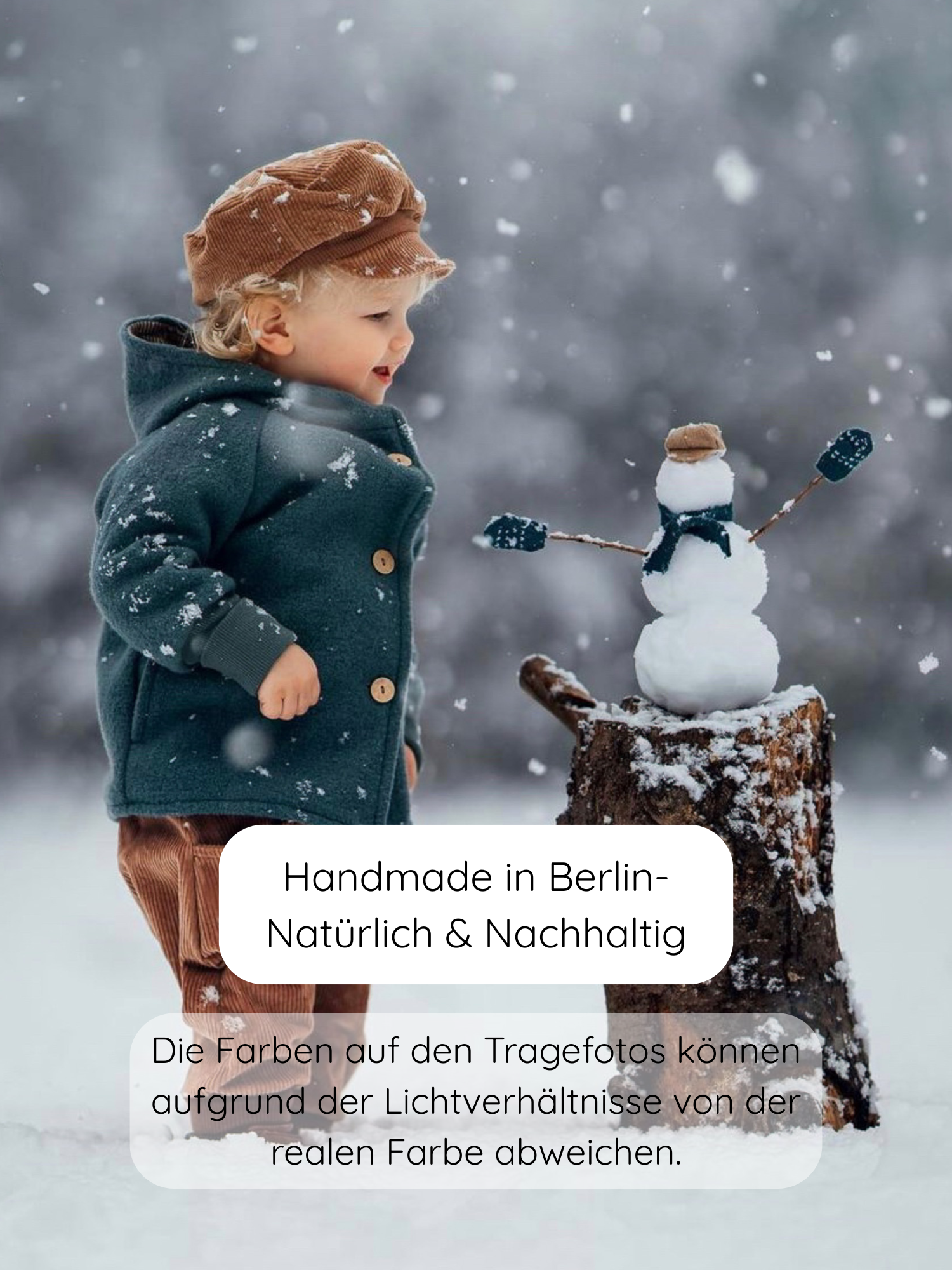 Kind steht im Schnee, trägt Michelmütze Breitcord Stretch - Weizen. Kind betrachtet einen kleinen Schneemann auf einem Baumstumpf. Mütze mit kleinem Schirm und Zugband, ideal für Windschutz.