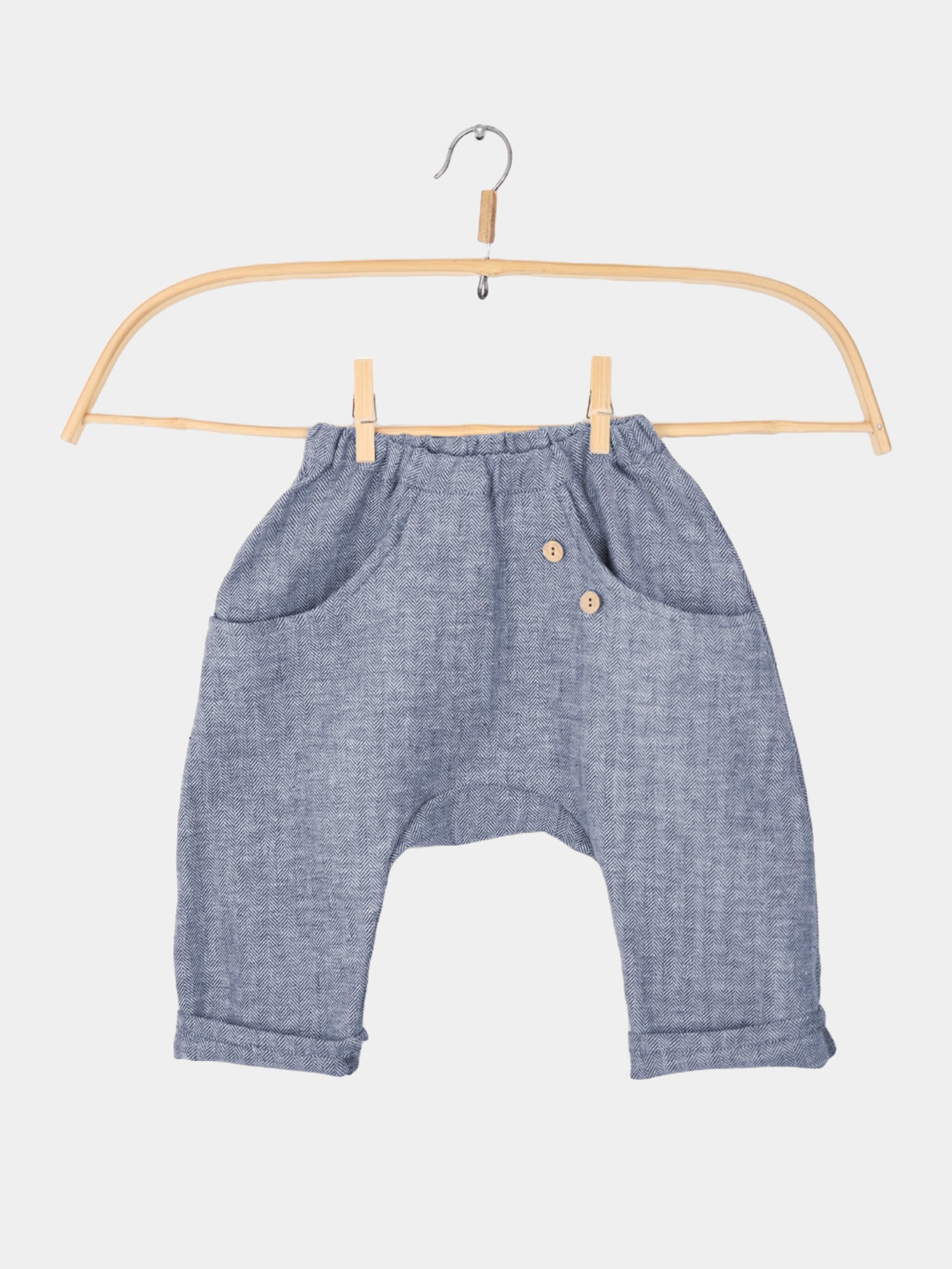Sommerknicker Fischgrat Blaubeere auf einer Wäscheleine mit Knopfdetails. Handgefertigt in Berlin, ideal für warme Tage, atmungsaktiv und krempelbar für variierende Längen. Kinderkleidung die nachhaltig produziert wird.