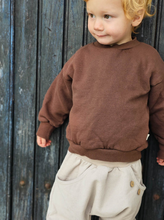 Weicher Pulli aus GOTS-zertifizierter Bio-Baumwolle in Schoko von petit cochon, ideal für Kita, Spielplatz oder Zuhause.