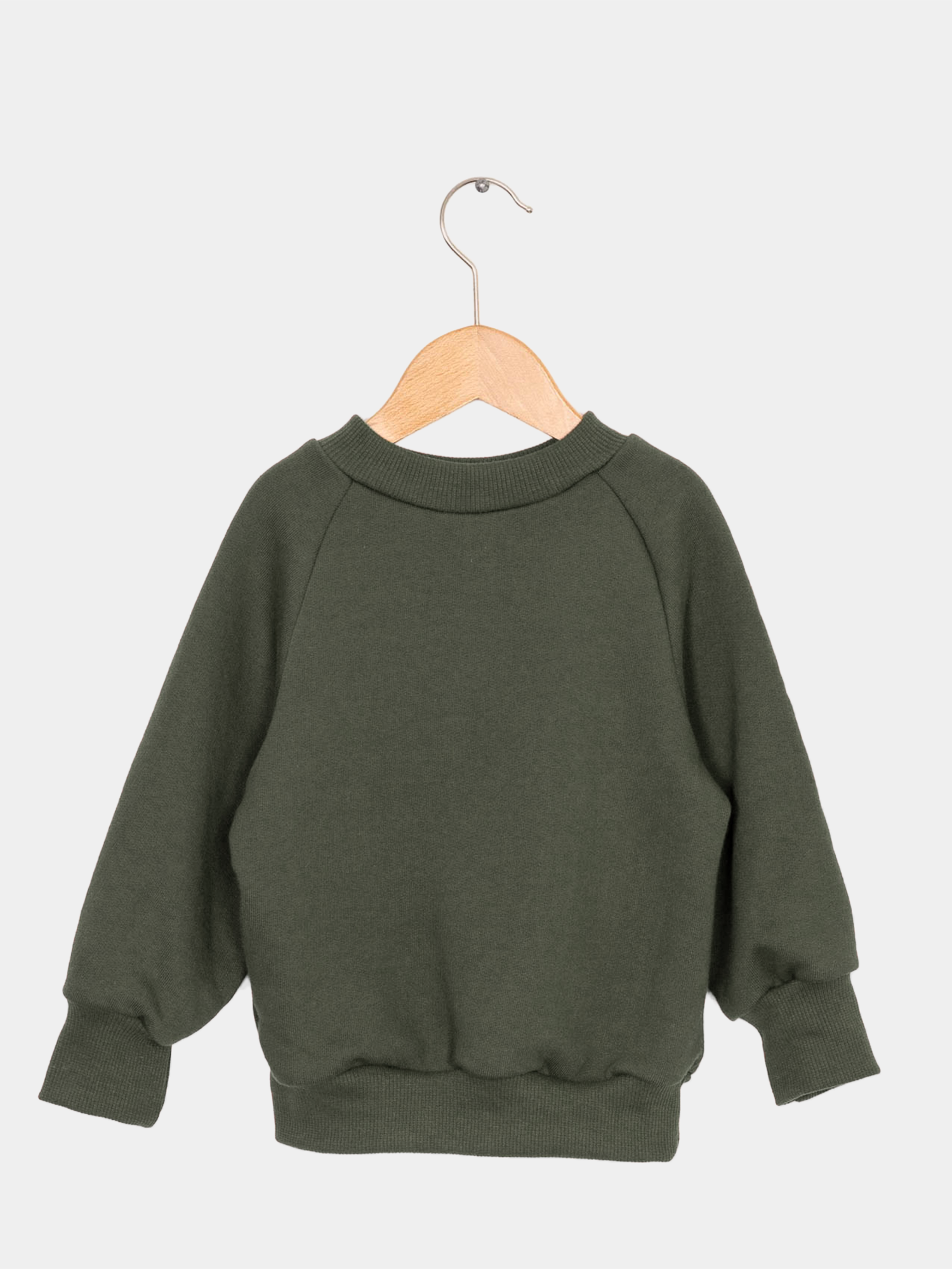 Pulli Bio-Sweat - Avocado aus GOTS-zertifizierter Bio-Baumwolle, weich und gemütlich, präsentiert auf einem Holzschaukelstuhl. Perfekt als Alltagsoberteil für Kinder, das mitwächst.