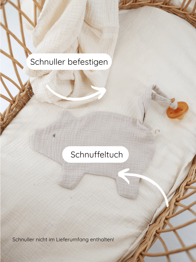Schnullertuch Baumwoll-Musselin - Sand liegt in einem kleinen Weidenkorb. Es ist ein graues, tierförmiges Schnuffeltuch mit Schlaufe zur Schnullerbefestigung, ohne Schnuller. Hinweis: Schnuller nicht im Lieferumfang enthalten!.