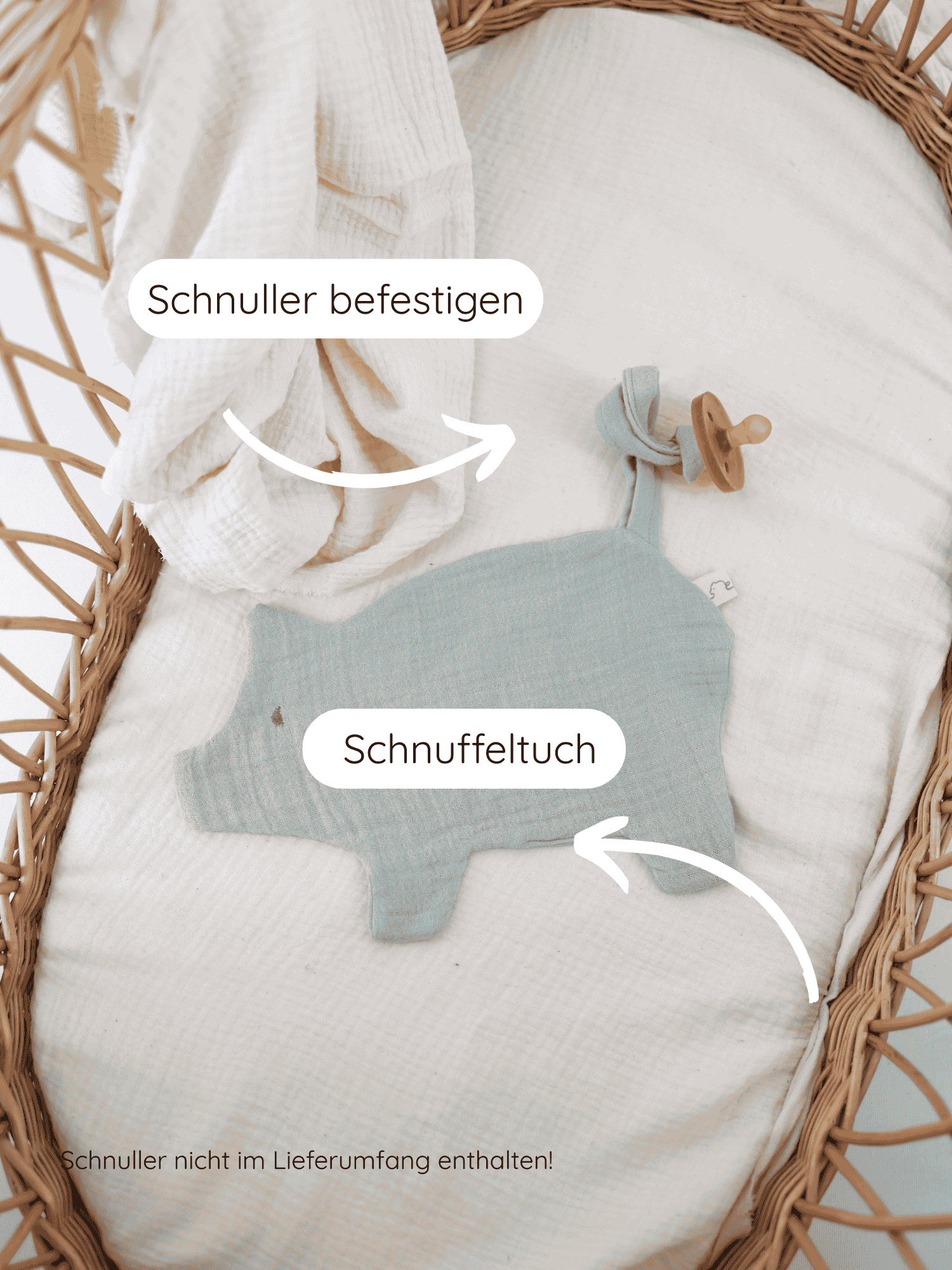 Schmusetuch/Schnullerband Schweinchen aus Baumwoll-Musselin - Mint: Im Moses-Korb liegt ein mintfarbenes Schnuffeltuch in Tierform mit einer Schlaufe, an der ein Schnullerband befestigt ist.