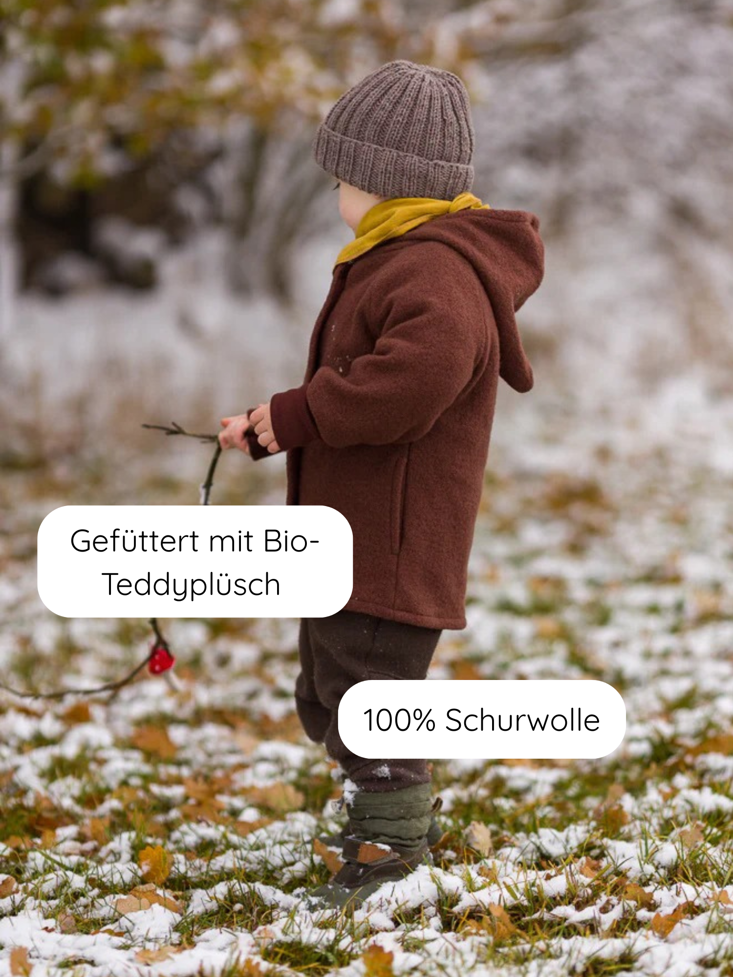 Ein Kind trägt die Teddy-Wichteljacke Wollwalk - Schoko, eine warme, wetterfeste Jacke mit spitzer Kapuze aus WOOLMARK-zertifiziertem Wollwalk, gefüttert mit Bio-Teddyplüsch, ideal für kalte Tage.