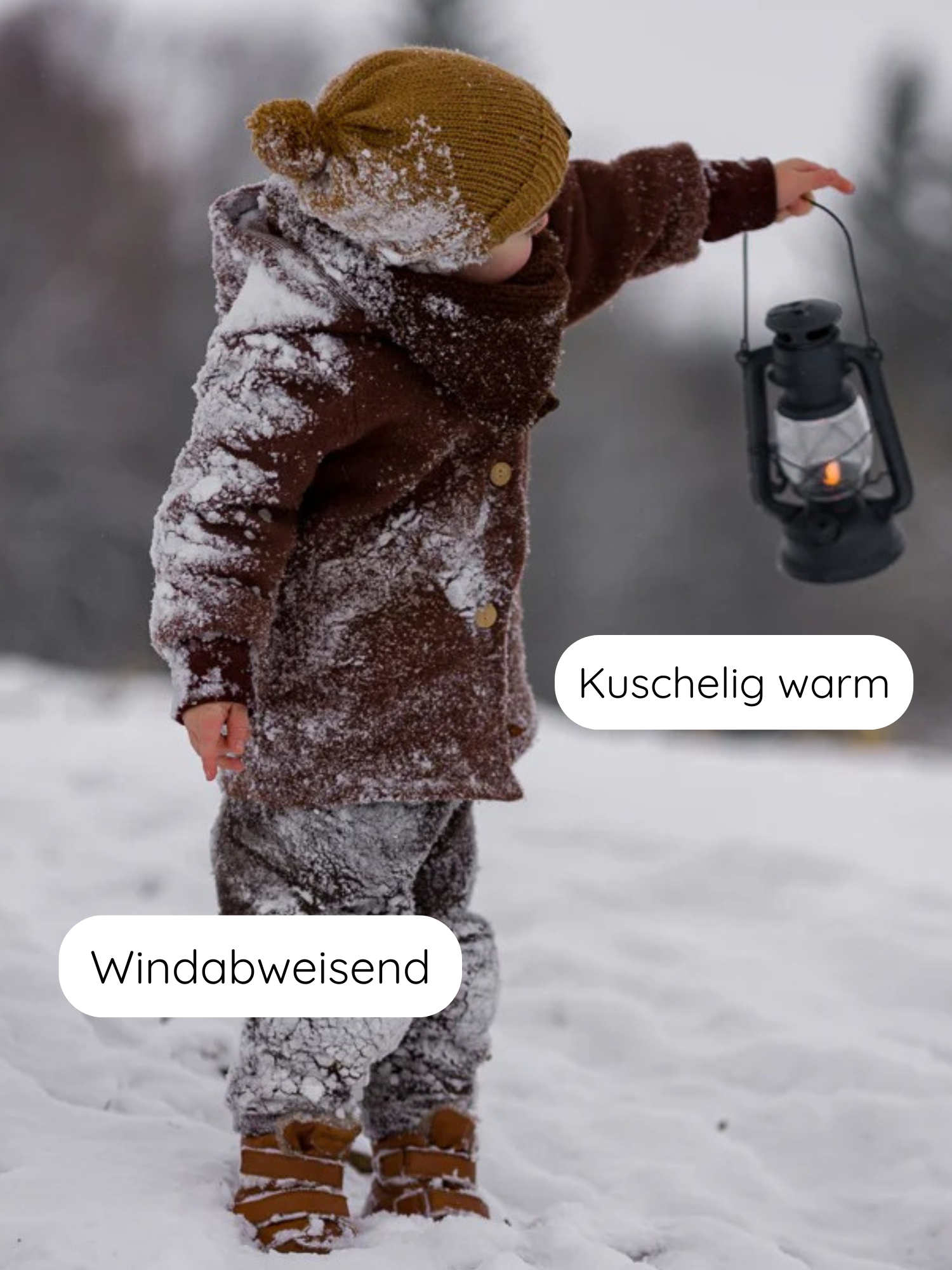 Ein Kind im Schnee trägt die Teddy-Wichteljacke Wollwalk - Schoko mit spitzer Kapuze, zeigt eine Laterne. Die Jacke ist windabweisend und kuschelig warm, ideal für kalte Tage.