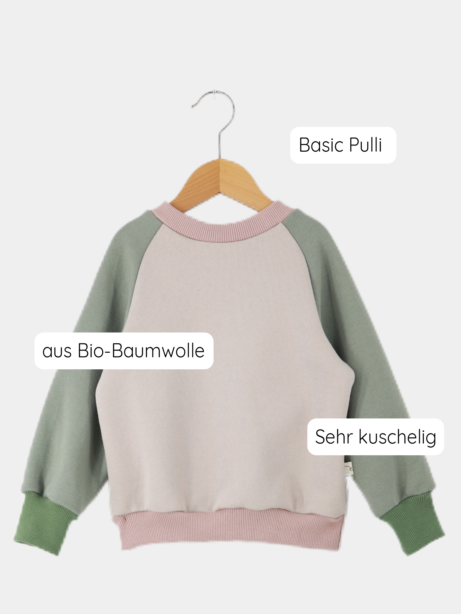 Upcycling-Pulli Bio-Sweat - Lollipop: Kinderpullover mit Raglanärmeln auf Holzkleiderbügel, aus 100% GOTS-zertifizierter Bio-Baumwolle, in Pastellfarben. Nachhaltig genäht aus Stoffresten, weich und kuschelig.