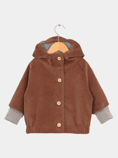 Wichteljacke Breitcord - Rost: Nahaufnahme eines braunen Breitcordärmels, gestreifte Kapuze. Weiche, robuste Jacke mit mitwachsenden Ärmeln, ideal für Kinder, mit großer Tasche für Schätze.