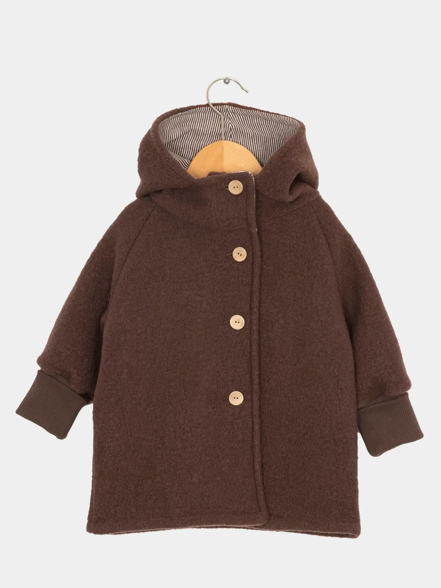 Wichteljacke Wollwalk - Schoko: Kinder-Winterjacke aus braunem, wollähnlichem Stoff mit Kapuze, vier runden Knöpfen und gerippten Bündchen, hängend an einem Holzbügel.