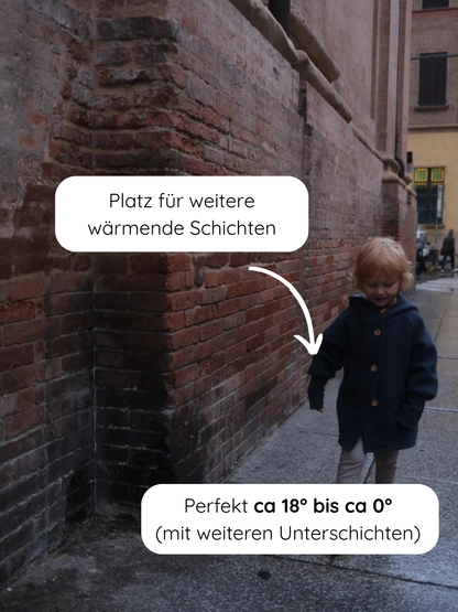 Kleines Kind trägt die Wichteljacke Wollwalk - Marine, eine dunkelblaue Jacke mit Holzknöpfen, ideal für Lagenlook bei 18° bis 0° C, perfekt für Herbst bis Frühling.