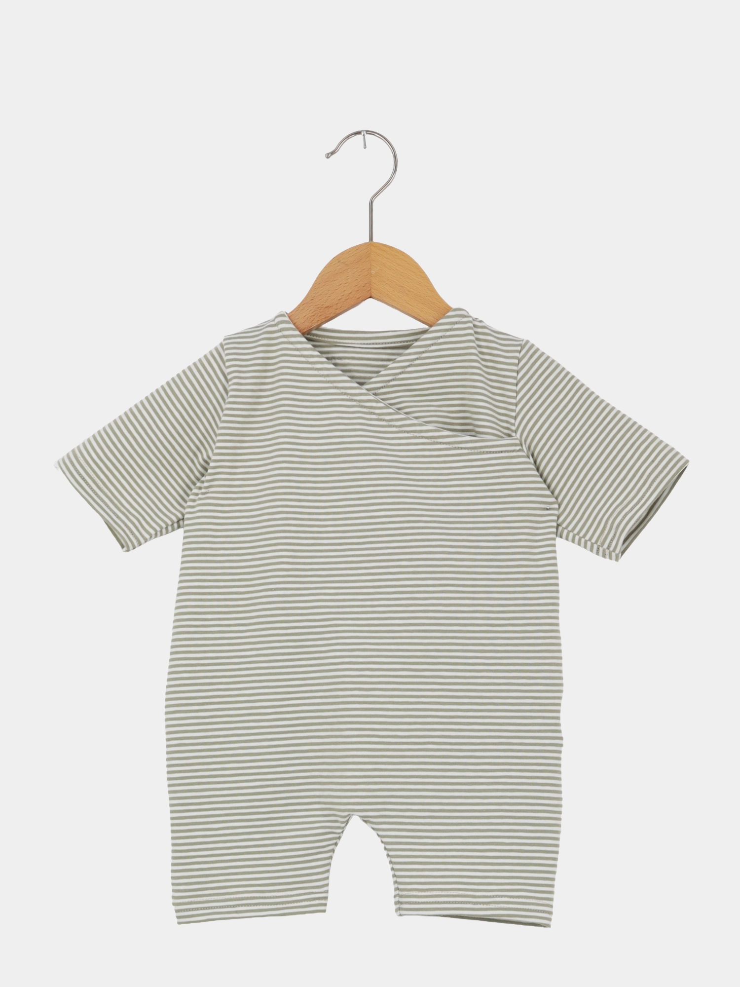 Kurzärmeliger Wickel Overall Baumwolle - Salbei mit schmalen Streifen auf einem Holzkleiderbügel, aus weichem, atmungsaktivem Bio-Musselin, ideal für warme Tage, mit praktischem Schrittverschluss für einfaches Wickeln.