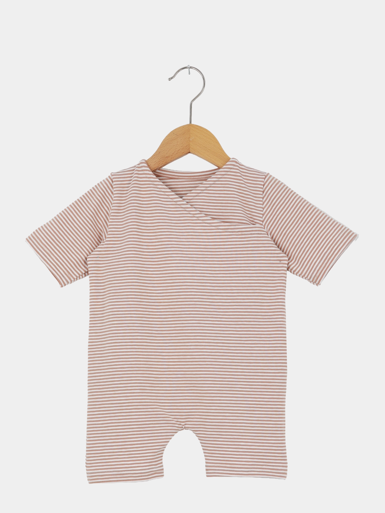Wickel Overall Baumwolle - Ringel Weizen: Kurzärmeliger Babystrampler mit feinen, horizontalen Streifen in Beige und Weiß, aus Bio-Baumwolle, mit Umschlagkragen und kurzen Beinen, auf Holzbügel präsentiert.