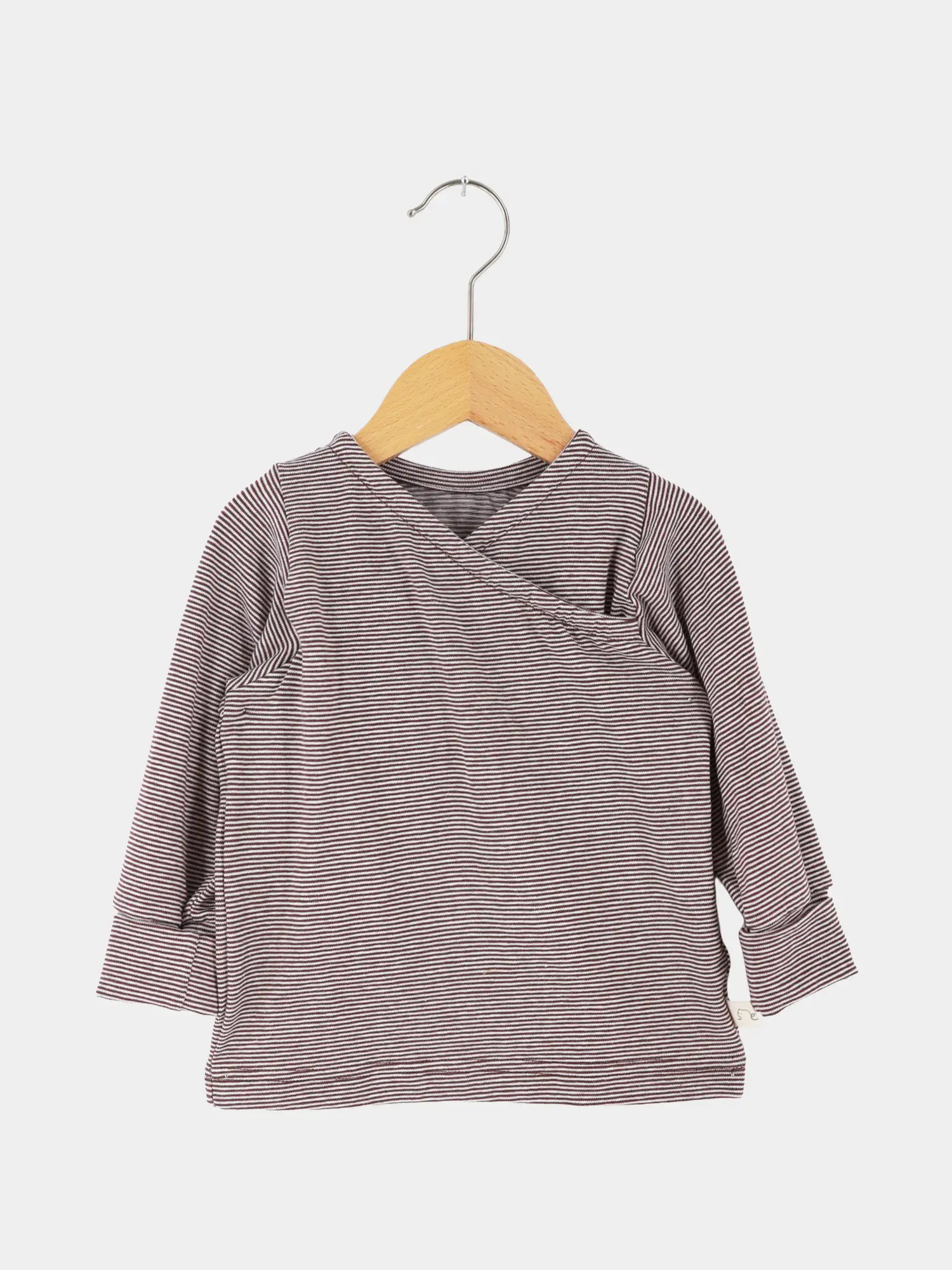 Wickelshirt aus Bio-Baumwolle - Ringel Schoko, langärmelig, mit Wickelstil vorne und krempelbaren Bündchen, hängt auf einem Holzkleiderbügel. Perfekt für Babys, einfach anzuziehen und mitwachsend.
