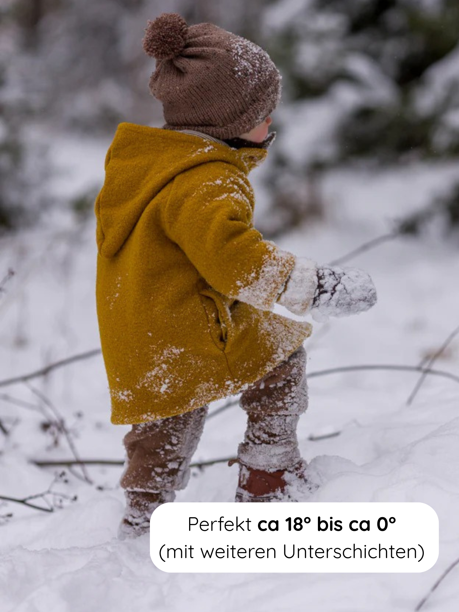 Kleinkind in einer Wichteljacke Wollwalk - Honig mit Kapuze, brauner Strickmütze und Schneehandschuhen, spaziert durch Schnee, ideal für Temperaturen von 18°C bis 0°C mit zusätzlichen Schichten.