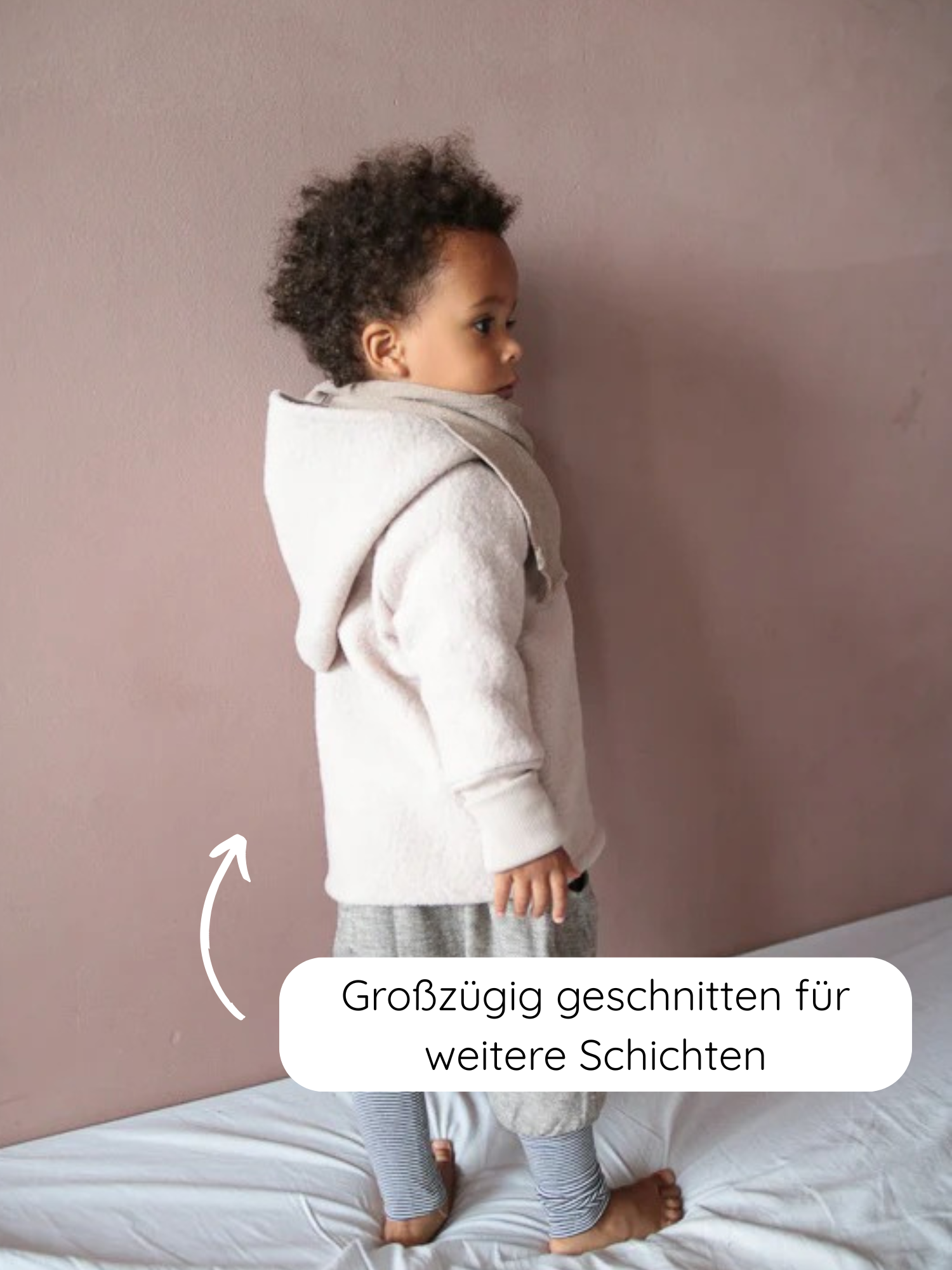 Kleinkind in Wichteljacke Wollwalk - Sand, zeigt großzügigen Schnitt für Schichten. Die Jacke aus Wollwalk bietet Bewegungsfreiheit und ist gefüttert mit Bio-Jersey, ideal für kühleres Wetter.