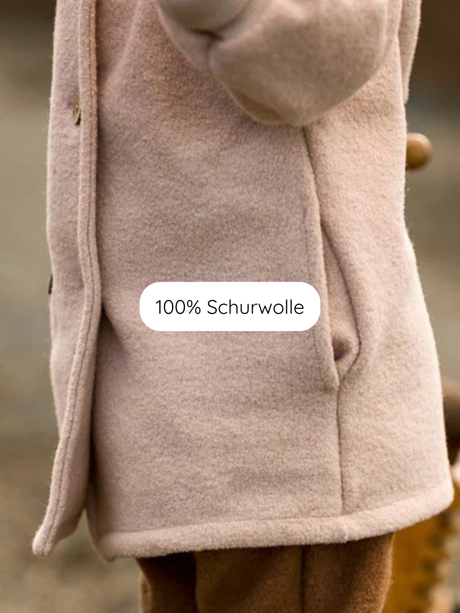 Winter Wichteljacke Wollwalk - Sand: Nahaufnahme eines Seitentaschenbereichs mit weicher, gebürsteter Textur, einem Etikett „100 % Schurwolle“ und braunen Hosen darunter.