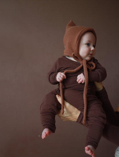 Baby trägt eine Zwergenmütze Strick - Nougat aus recycelter Baumwolle, mit elastischem Sitz und Bindeband, perfekt für Herbst und Winter. Erstausstattung Babys. Perfekte Baby Geschenke.