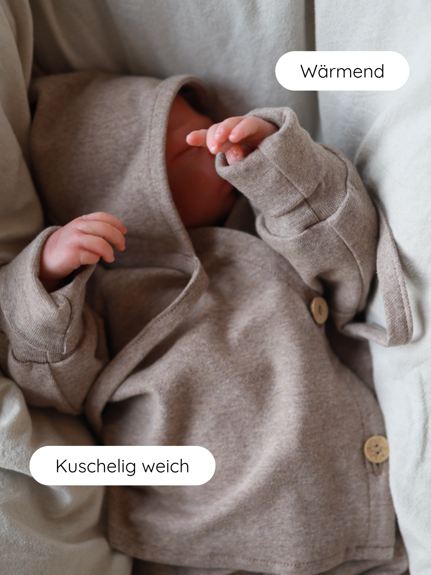 Neugeborenes in heather-beiger Zwergenmütze Feinstrick - Hafer Meliert, auf einem gepolsterten Nest liegend, betont durch Wärmend und Kuschelig weich Labels, zeigt weichen, anschmiegsamen Stoff mit Holzknöpfen.