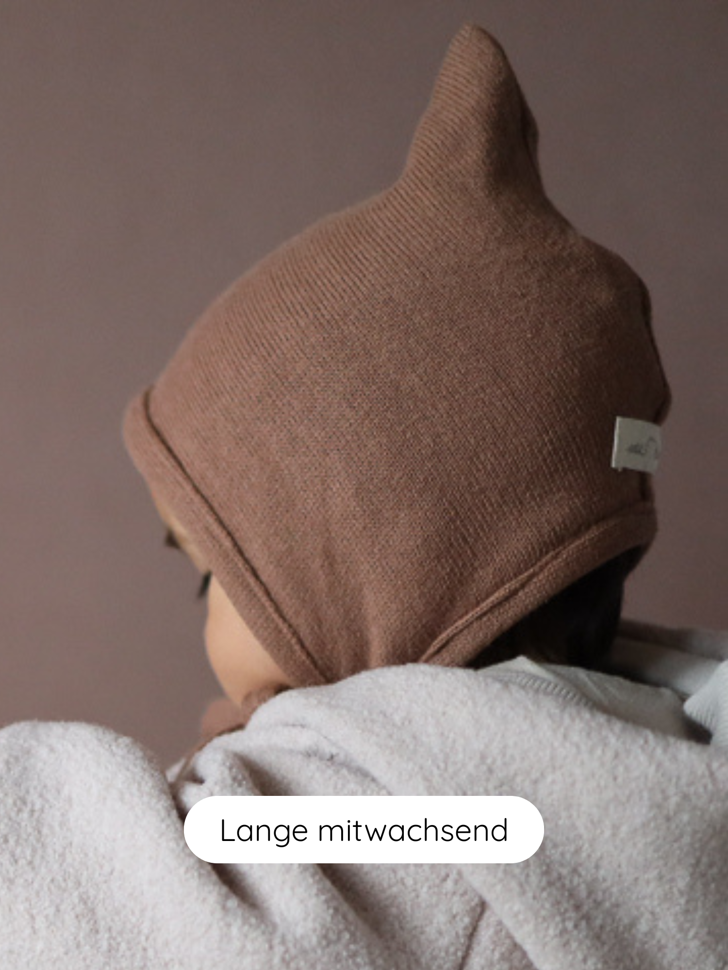 Das Bild zeigt die Zwergenmütze Strick - Nougat, eine weiche, braune Babymütze aus geripptem Strick mit Spitze und umgeschlagenem Rand, aus recycelter Baumwolle, anpassbar und gemütlich für Herbst und Winter.